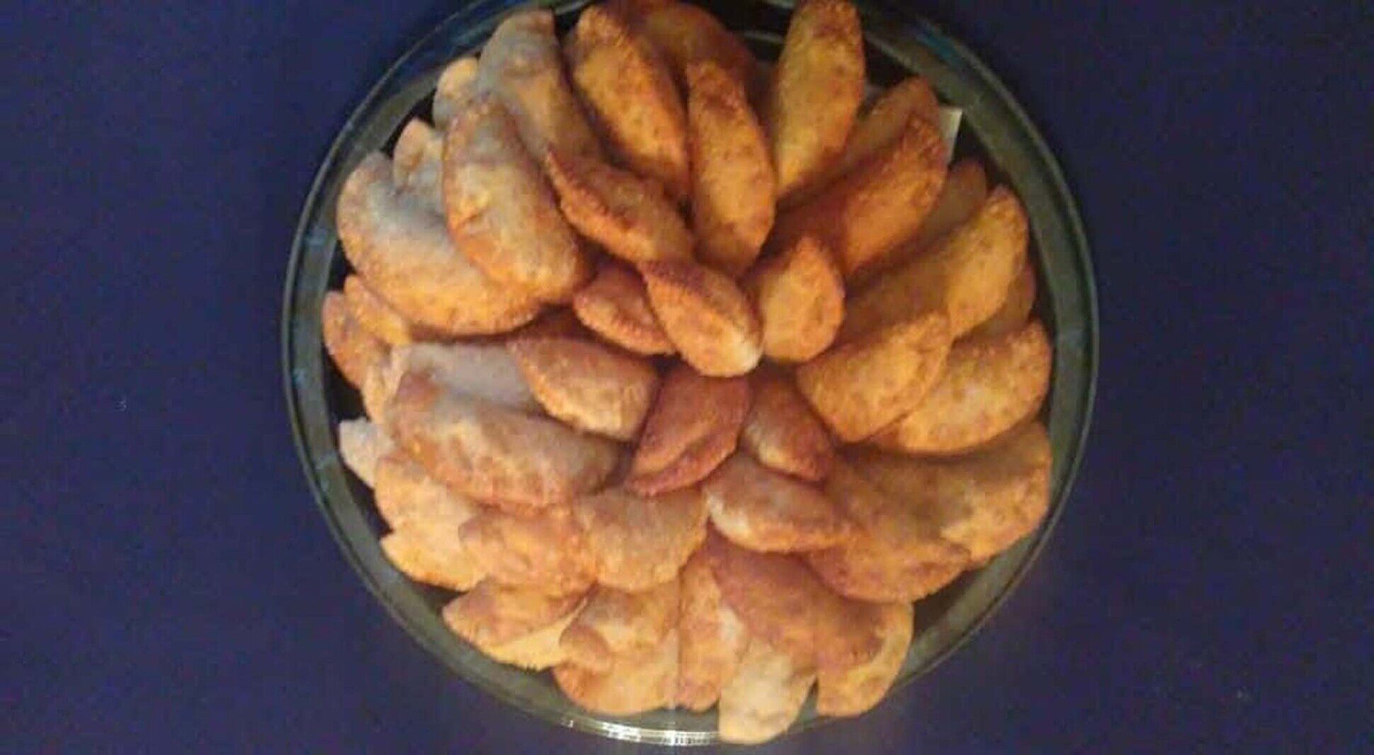 Large catering platter filled with golden handcrafted empanadas